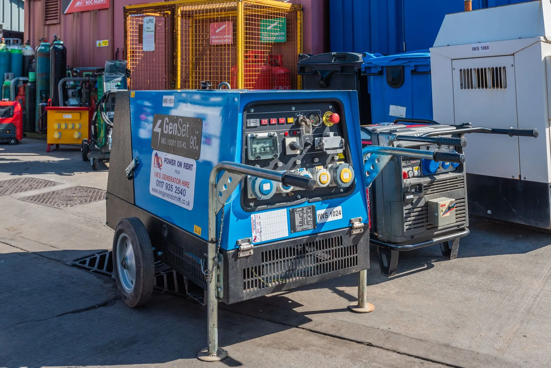 A blue machine is parked in front of a building.