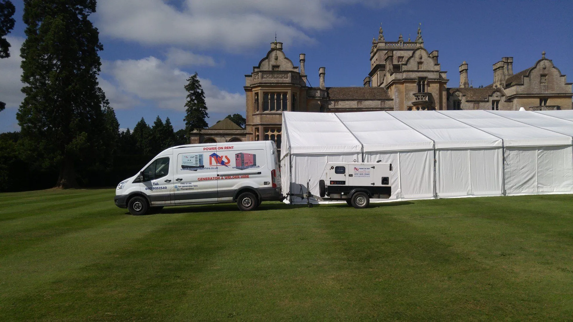 A white van parked in front of a large building.